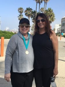 Kathy Bates Wearing Medal Posing With Brunette Woman In Black Tank and Pants